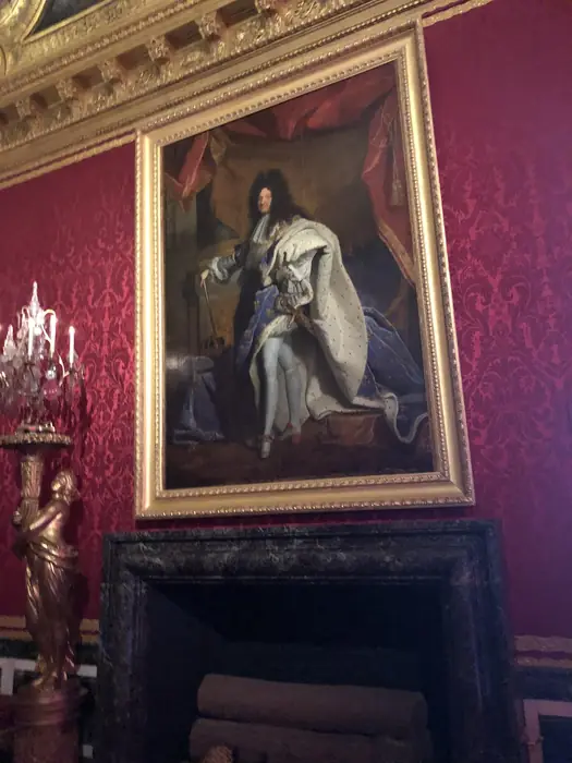 Another royal portrait, framed in gold against figured silk.