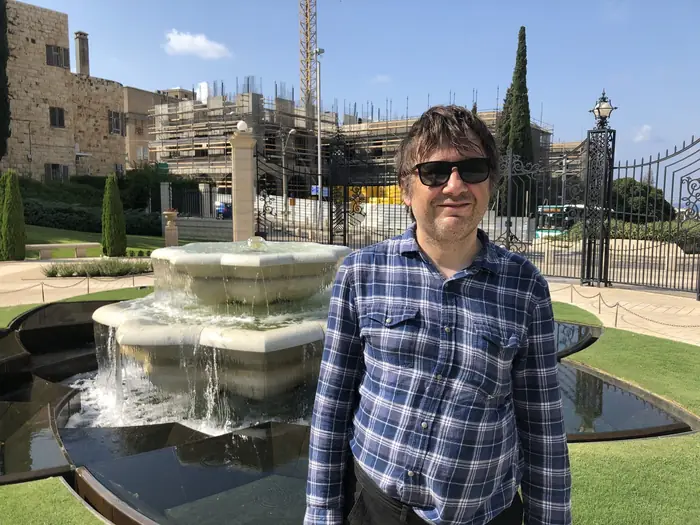 A fountain and cypresses in the gardens at Haifa.