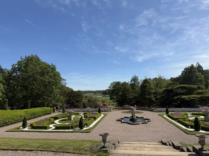The Italian garden, its fountain and parterre falling away towards the mere.